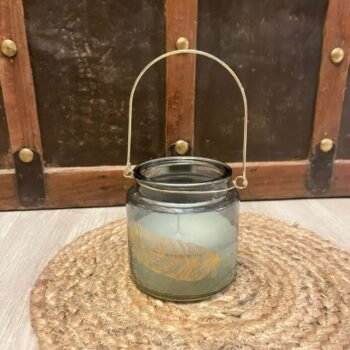 Fanal Vela aromatica en frasco de vidrio con manija y pluma estampada dorada de 10 x 10 cm