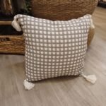 Almohadon tejido gris y blanco con borlas de 50 x 50 cm