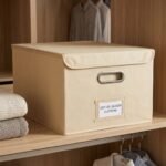 Organizador grande de ropa textil beige con asa metalica de 54 × 44 × 32 cm